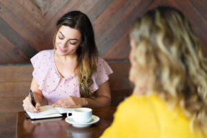 Two Women Drinking Coffee Making Notes Cafe 300x200