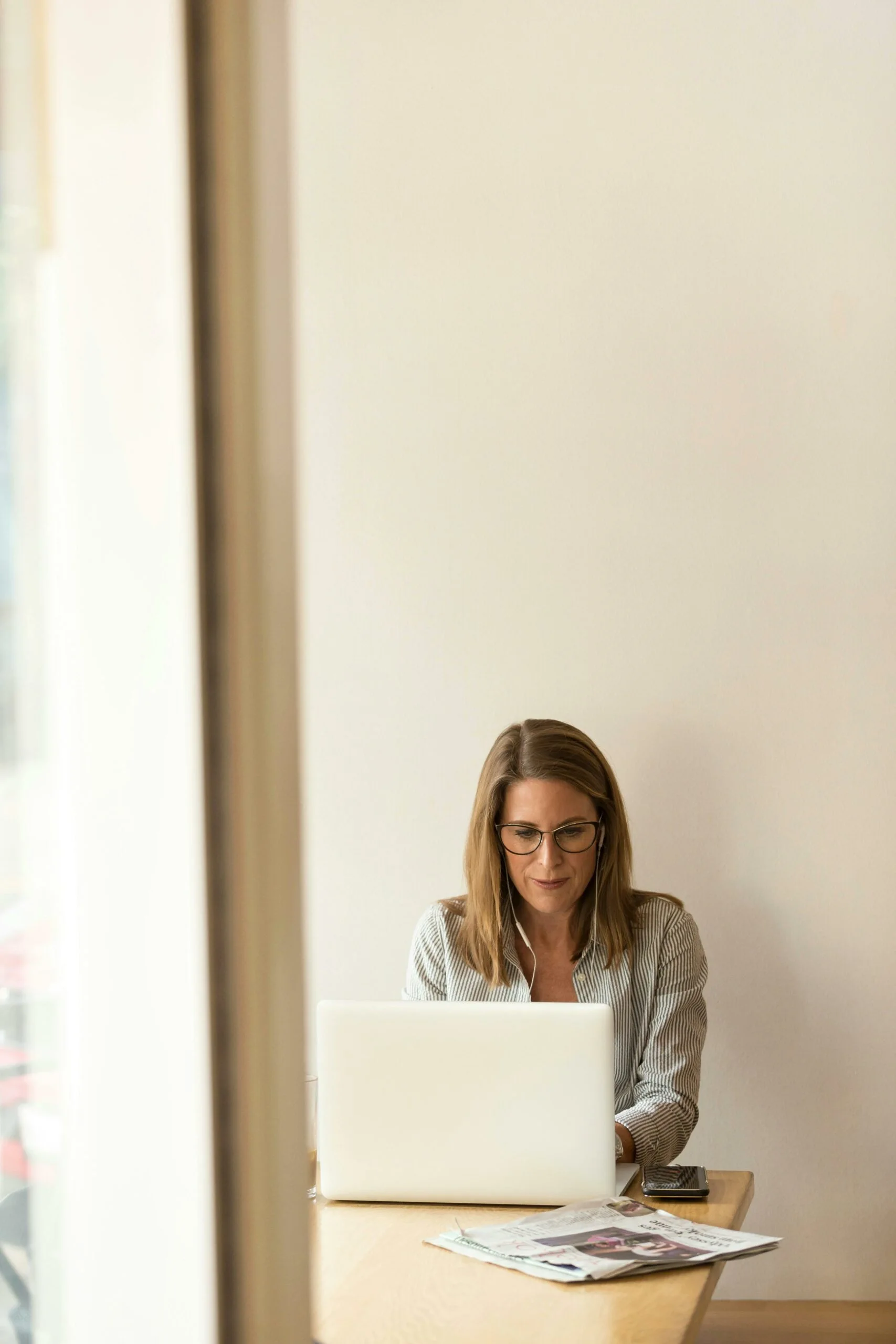 Femme travaillant devant un ordinateur avec un casque audio